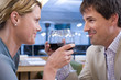 Couple proposing toast with wine glasses in restaurant, close-up