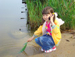 Photo: Little girl on the riverside. Game and mobile communication. Little girl on the riverside. Game and mobile communication.