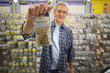 Man with bag of screws in hardware store, portrait