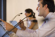 Businessman speaking into microphone at conference