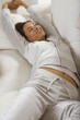 A woman stretching on a couch.