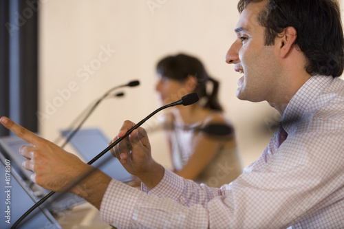 Photo: Businessman speaking into microphone at conference Businessman speaking into microphone at conference