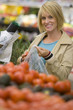 Woman choosing tomatoes in grocery store