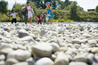 Friends walking on pebbles with their cycles.