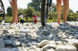 Friends walking on pebbles with their cycles.