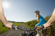 A woman giving her friend an apple while cycling.