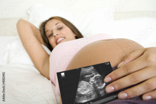Photo: Pregnant woman displaying sonogram image Pregnant woman displaying sonogram image