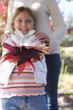 Young girl displaying handful of autumn leaves