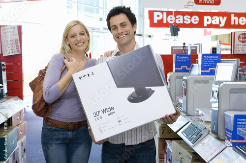 Foto: Young couple shopping, with computer in box, smiling, portrait Young couple shopping, with computer in box, smiling, portrait