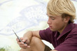 Portrait of a young man on a mobile in front of a graffiti covered wall