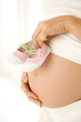 A mother holding a pair of baby shoes