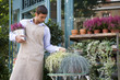 Male florist arranging the plant display outside his shop