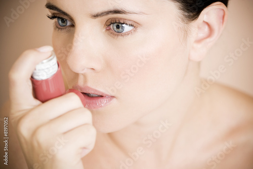 Photo: Female asthma sufferer using an inhaler Female asthma sufferer using an inhaler