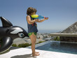 A boy playing with a water gun.