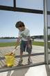 A boy cleaning the glass door.