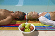 Couple lying down beside the pool