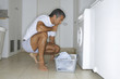 Man putting clothes in the washing machine.