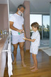 Father giving son shaving foam.