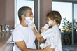 Father and son applying shaving foam.