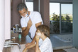 Father and son shaving in the bathroom.