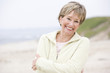 Photo: Woman at the beach with arms crossed smiling Woman at the beach with arms crossed smiling