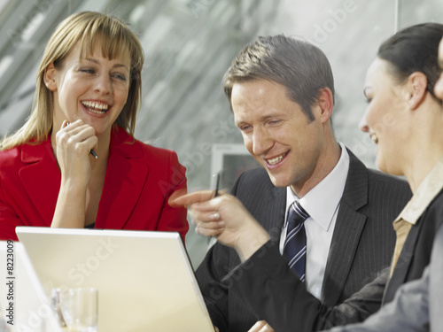 Photo: Two businesswomen and a businessman smiling in a meeting Two businesswomen and a businessman smiling in a meeting