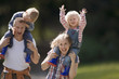Photo: Two generation family walking along country path, children (2-4) on parents shoulders, smiling Two generation family walking along country path, children (2-4) on parents shoulders, smiling
