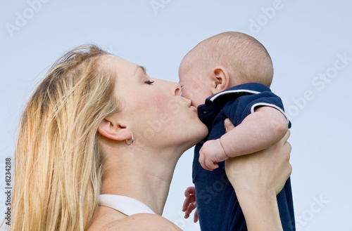 Photo: Mother Holding Son Up Kissing Him on Cheek Mother Holding Son Up Kissing Him on Cheek
