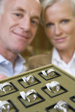 Photo: Mature male and female jewellery shop assistants with tray of rings, smiling, portrait Mature male and female jewellery shop assistants with tray of rings, smiling, portrait