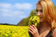 Beautiful girl among blooming raps field with flower Beautiful girl among blooming raps field with flower