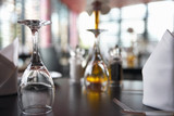 Photo: Upside down wine glasses on restaurant table, close-up, surface level, focus on foreground Upside down wine glasses on restaurant table, close-up, surface level, focus on foreground