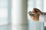 Photo: Businessman using personal electronic organiser and digital pen, side view, mid-section Businessman using personal electronic organiser and digital pen, side view, mid-section