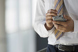 Photo: Businessman using personal electronic organiser and digital pen, close-up, mid-section Businessman using personal electronic organiser and digital pen, close-up, mid-section