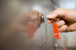 Photo: Woman holding red key ring, turning key in door lock, side view, close-up, focus on hand Woman holding red key ring, turning key in door lock, side view, close-up, focus on hand