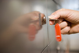 Photo: Woman holding red key ring, turning key in door lock, side view, close-up, focus on hand Woman holding red key ring, turning key in door lock, side view, close-up, focus on hand