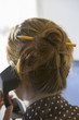 Photo: Businesswoman using telephone, pencil threaded through ginger hair bun, close-up, rear view Businesswoman using telephone, pencil threaded through ginger hair bun, close-up, rear view