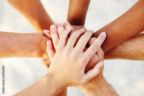 Foto: young peoples hands linked together young peoples hands linked together