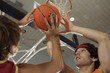 Two young men playing basketball