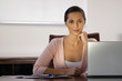 Portrait of a businesswoman sitting in front of a laptop and smirking