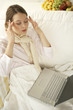 Photo: High angle view of a mid adult woman suffering from a headache with a laptop on her lap High angle view of a mid adult woman suffering from a headache with a laptop on her lap
