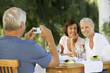 Foto: A group of senior couples at a restaurant, man taking picture with digital camera A group of senior couples at a restaurant, man taking picture with digital camera