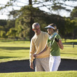 Man teaching a woman how to play golf