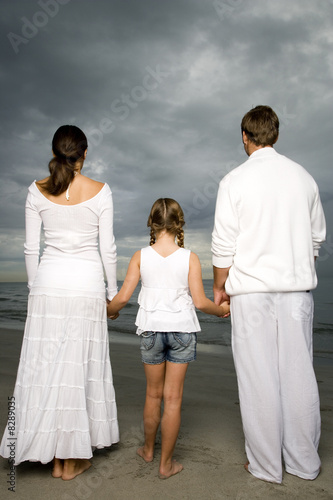 Photo: A couple with their daughter on a beach A couple with their daughter on a beach