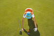 High angle view of a mid adult woman judging a golf ball on a golf course