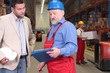 manager and older worker talking  in warhouse