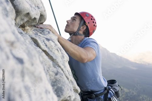 Photo: A climber climbing a rock face A climber climbing a rock face