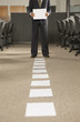 Low section view of a businessman holding a paper