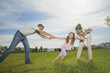 Family pulling arms of daughter
