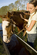 Woman with horse drinking water