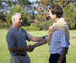 Two men shaking hands on a golf course
